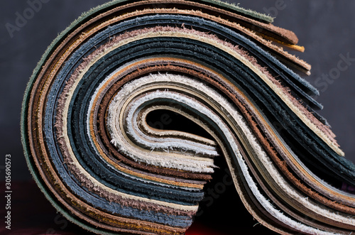 Closeup of rolled samples of upholstery leather against dark background