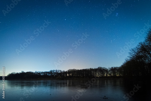 Sterne in der Nacht über dem See im Winter