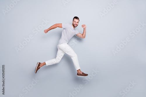 Full length body size view of his he nice attractive sportive cheerful cheery purposeful strong bearded guy running fast discount isolated over light grey pastel color background © deagreez