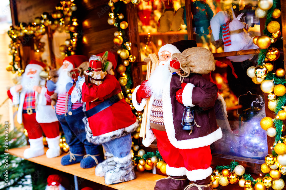 christmas market in Germany cute Santa Clause called Weihnachtsmann in German decoration, gifts, Xmas tree balls and illumination for sale