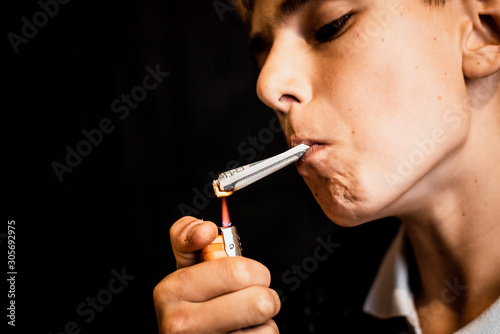 A teenager lighting a cigarette or drugs is a rolled dollar, the concept of teen addiction and spending money horor