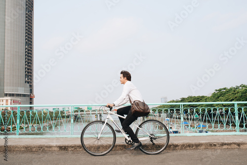 Fototapeta Naklejka Na Ścianę i Meble -  Asian man mad riding bicycle in urban city commuting with speed and hipster trendy transportation