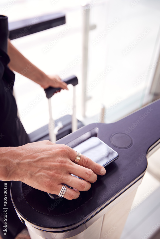 Obraz premium Close Up Of Passenger In Airport Departure Lounge Scanning Digital Boarding Pass On Smart Phone