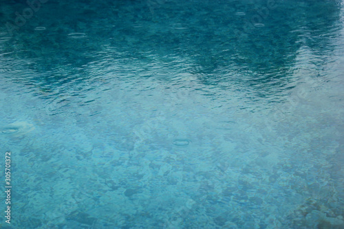 Abstract blured image of water in swimming pool with reflections for background