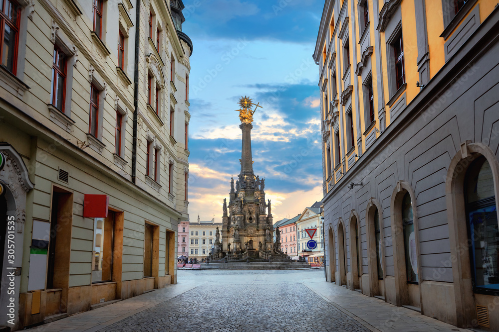 Street in centre city with view to square and monument of Holy Trinity Column. Olomouc, Czech Republic