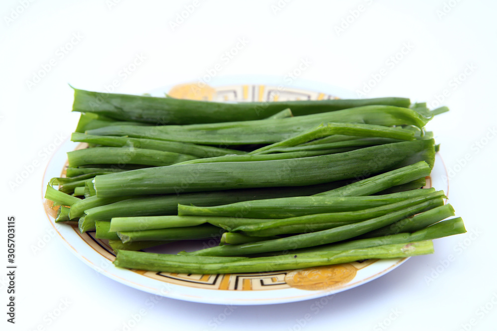 green onion on white background . onions which are green onions white plate with some smaller green onions sliced next to it on a kitchen table. green onion on white background . onions which are green onions white plate with some smaller green onions sliced next to it on a kitchen table.
