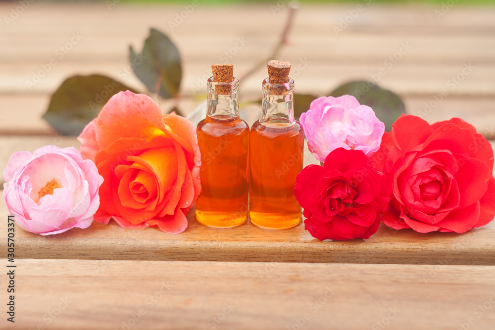 Essence of rose on table in beautiful glass bottle
