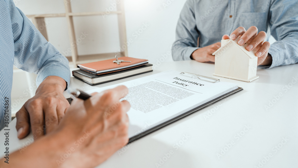 broker agent and customer holding pen, the policyholder and explain discussing for concerning mortgage loan offer for and house insurance. broker agent and customer holding pen, the policyholder and explain discussing for concerning mortgage loan offer for and house insurance.