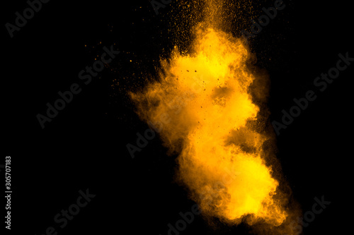 Abstract orange powder explosion on black background. Freeze motion of orange powder splash.