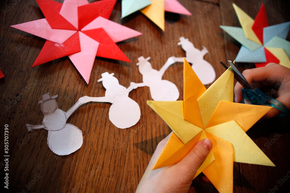 Kinder basteln, falten Weihnachtsstern Origami Stern und Schneemann aus  buntem Papier in der Weihnachtszeit im Winter Stock Photo | Adobe Stock