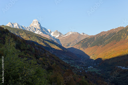 Panoramic views of the mountains and Ushguli peak in the snow, visible in the distance, in the mountainous part of Georgia - Svaneti at sunset