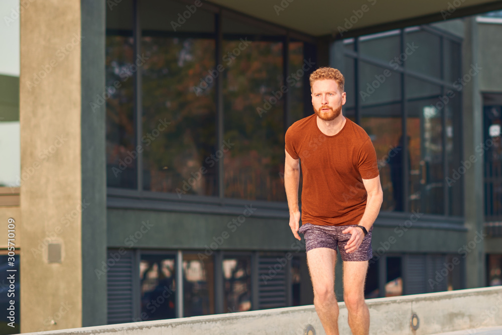 Young man exercising / running in urban park.