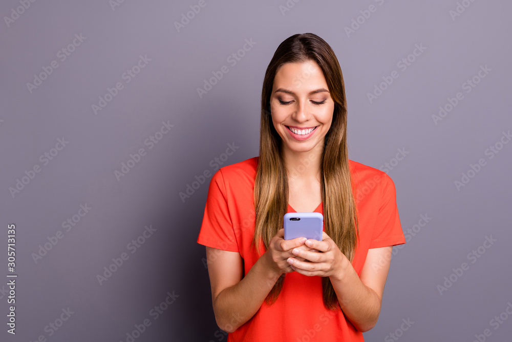 Portrait of cheerful girl use her smartphone follow bloggers chatting with friends wear casual style clothing isolated over grey color background Portrait of cheerful girl use her smartphone follow bloggers chatting with friends wear casual style clothing isolated over grey color background