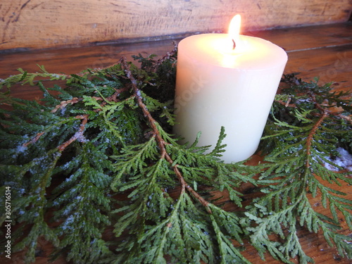 A candle on cedar branches for christmas