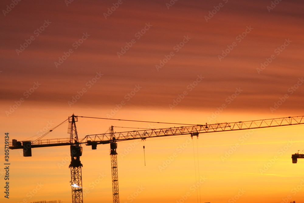 construction cranes on the background of an unusual sunset