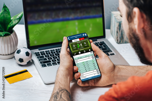 Konstfotografi Man making bets online using mobile application on his phone