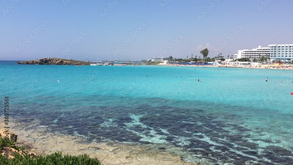 Cyprus, Ayia Napa, Nissi beach with white sand. Sunbathing and swimming people. Mediterranean resort. Cyprus, Ayia Napa, Nissi beach with white sand. Sunbathing and swimming people. Mediterranean resort.