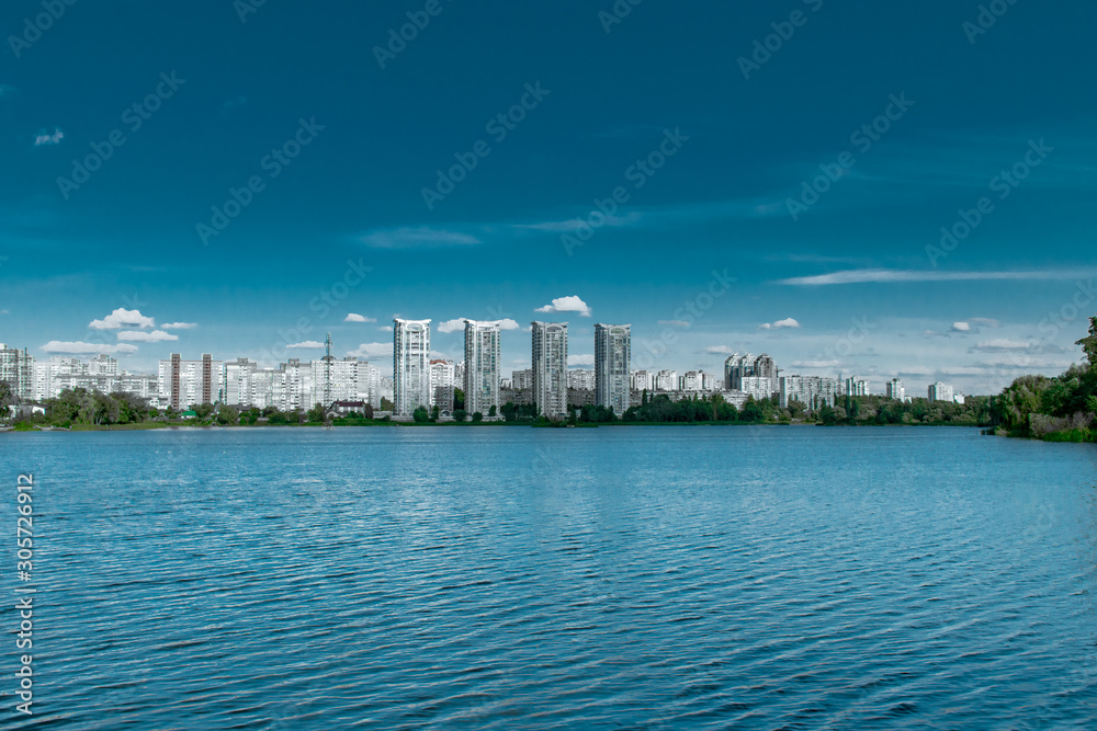 Tall buildings on the shore of a blue lake