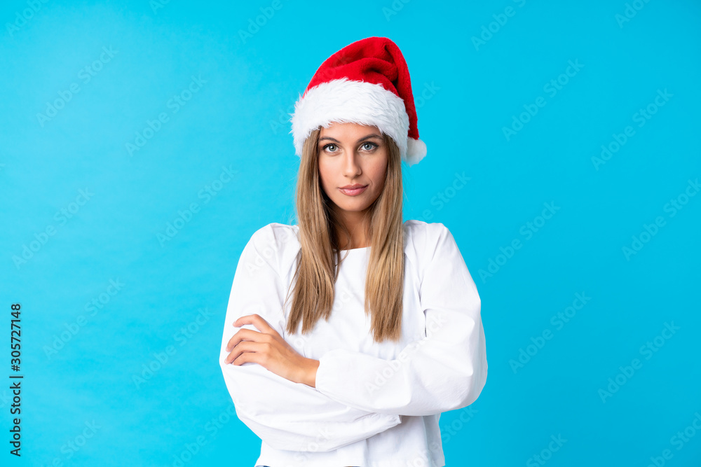 Girl with christmas hat over isolated background keeping arms crossed Girl with christmas hat over isolated background keeping arms crossed
