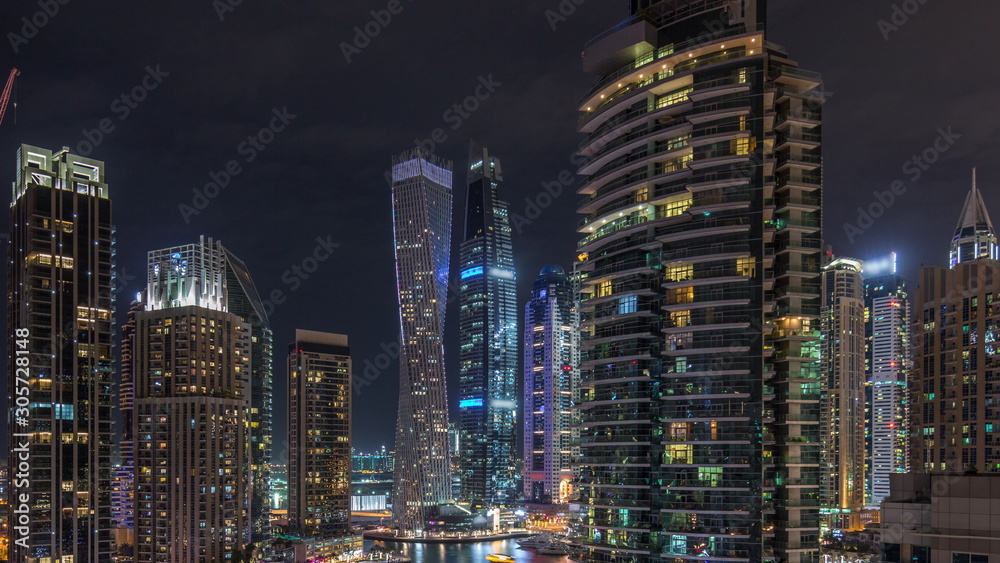 View of various skyscrapers and towers in Dubai Marina from above aerial night timelapse