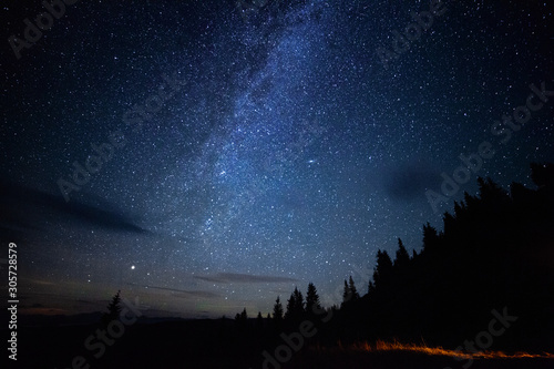 Milky way long exposure astrophotography night sky with stars outdoor scene in mountains forrest. Adventure lifestyle astronomy concept. Cosmic atmosphere universe landcape.