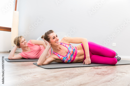 Smiling young women doing exercise