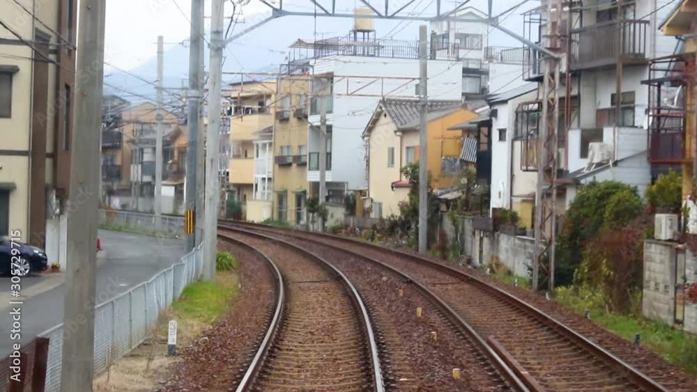 Slow Motion View From Inside The Front Of A Japanese Rail Train Passing Houses And Buildings On A Rainy Day In Japan Slow Motion View From Inside The Front Of A Japanese Rail Train Passing Houses And Buildings On A Rainy Day In Japan