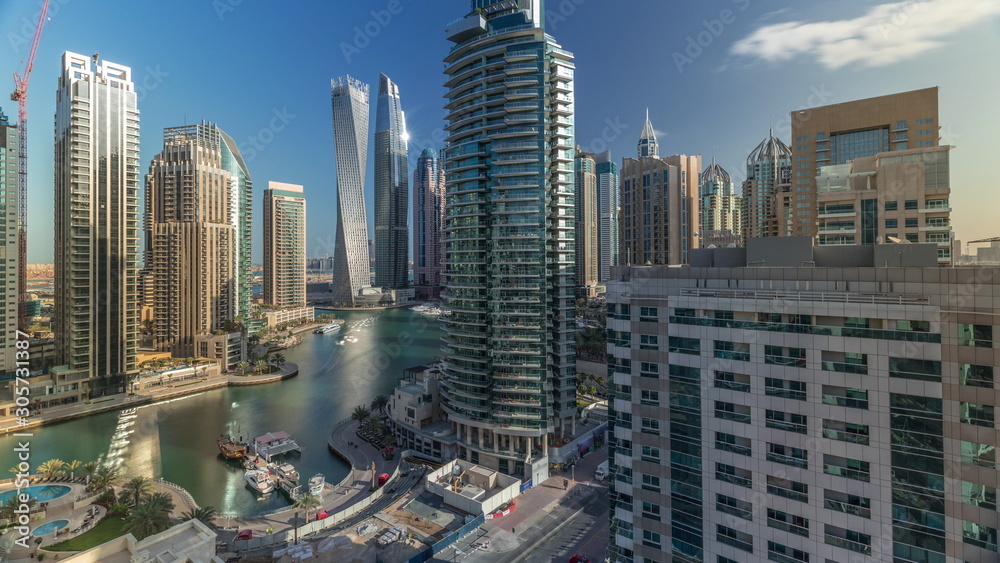 Obraz premium Widok z lotu ptaka na wieżowce mieszkalne i biurowe Dubai Marina z timelapse waterfront
