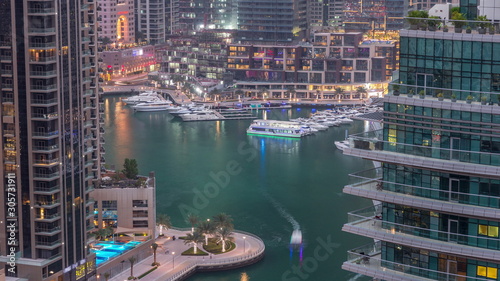 Aerial view of Dubai Marina residential and office skyscrapers with waterfront day to night timelapse