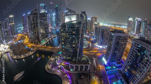 Aerial view of Dubai Marina residential and office skyscrapers with waterfront night timelapse