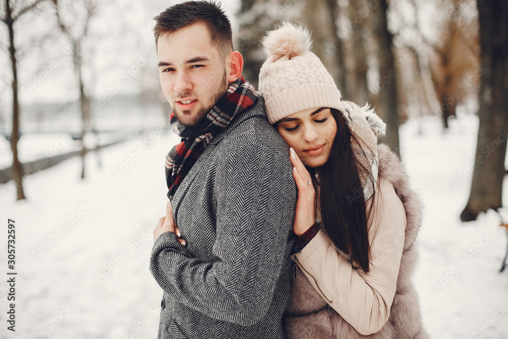 Couple in a winter park. Beautiful girl in a fur coat. Man in a jeans jacket. Couple in a winter park. Beautiful girl in a fur coat. Man in a jeans jacket.