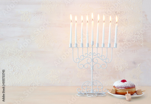 religion image of jewish holiday Hanukkah background with menorah (traditional candelabra), spinning top and doughnut over white background