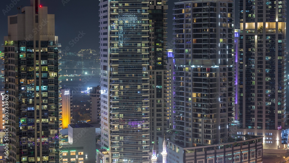 View of various skyscrapers and towers in Dubai Marina from above aerial night timelapse