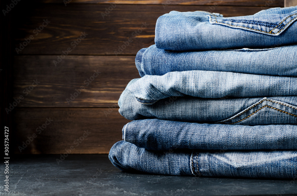 Denim. Lots of blue jeans on wooden background. Denim. Lots of blue jeans on wooden background.