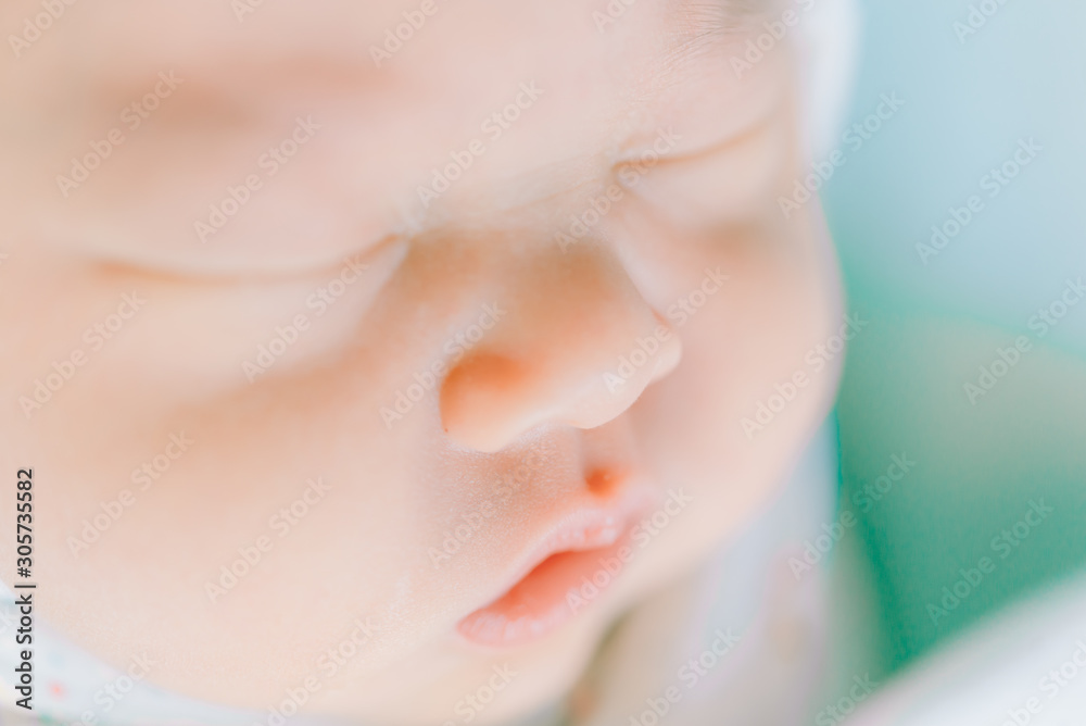 Fototapeta premium tender lips and nose of a newborn baby asleep on a diaper