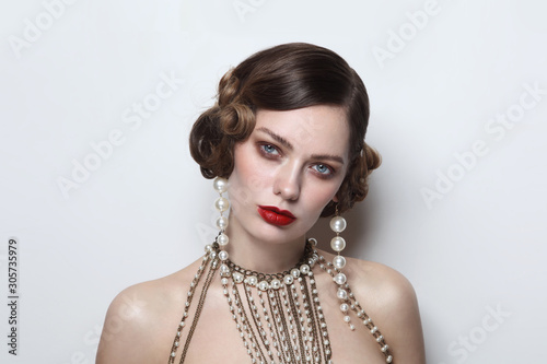 Vintage style portrait of young beautiful woman with fancy pearl earrings and necklace