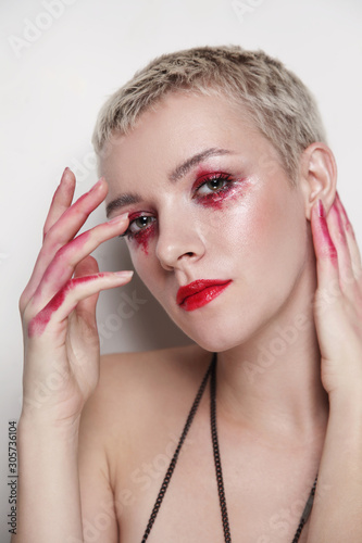 Young beautiful woman with short haircut and fancy red makeup