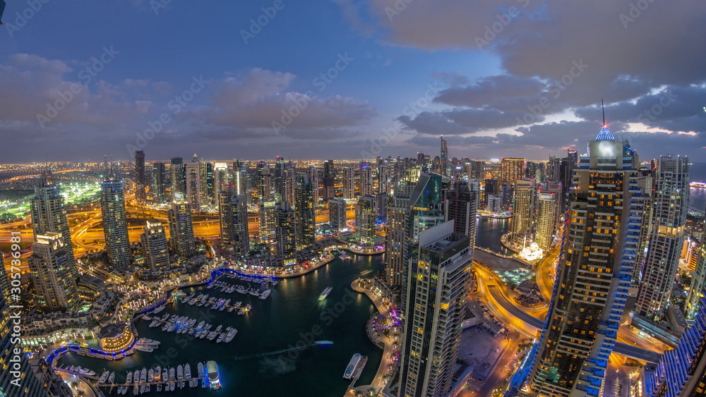 Dubai Marina skyscrapers and jumeirah lake towers view from the top aerial day to night timelapse in the United Arab Emirates.