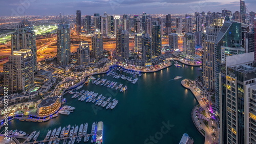 Fototapeta Naklejka Na Ścianę i Meble -  Dubai Marina skyscrapers and jumeirah lake towers view from the top aerial day to night timelapse in the United Arab Emirates.