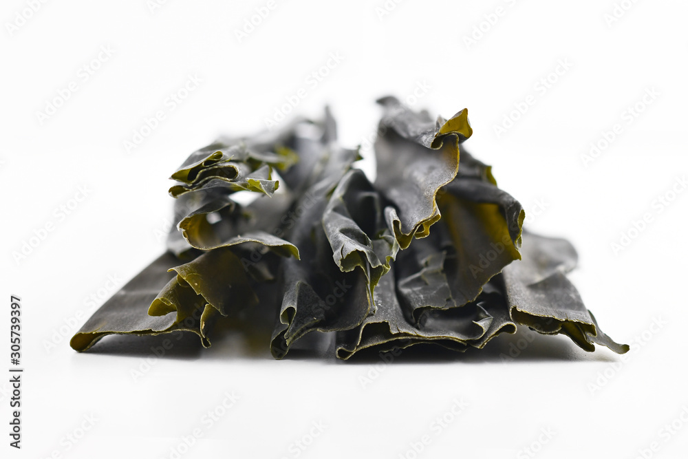 Dried sheets of kombu, an edible kelp algae, also called  dasima or haidai, that is widely eaten in East Asia and especially Japan, isolated on white background - obrazy, fototapety, plakaty 
