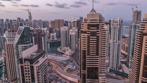 Dubai Marina skyscrapers and jumeirah lake towers view from the top aerial night to day timelapse in the United Arab Emirates.