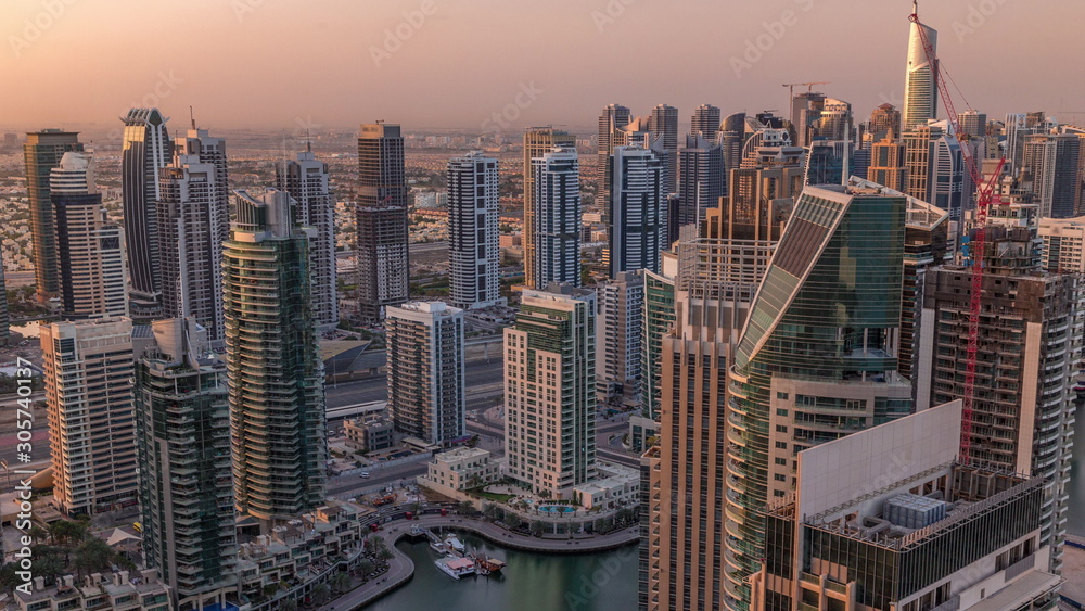 Dubai Marina skyscrapers and jumeirah lake towers sunrise view from the top aerial timelapse in the United Arab Emirates.