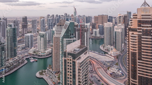 Dubai Marina skyscrapers and jumeirah lake towers view from the top aerial night to day timelapse in the United Arab Emirates.