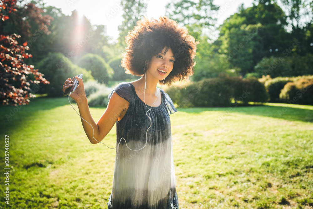 Φωτογραφία Young woman dancing listening to the music with earphones from the smart phone i