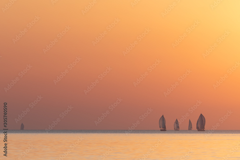 Sailing boats during sunset over a calm sea