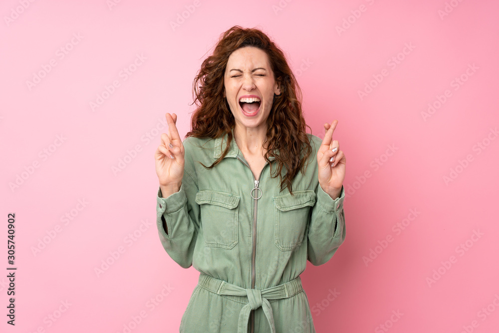 Young pretty woman over isolated pink background with fingers crossing Young pretty woman over isolated pink background with fingers crossing