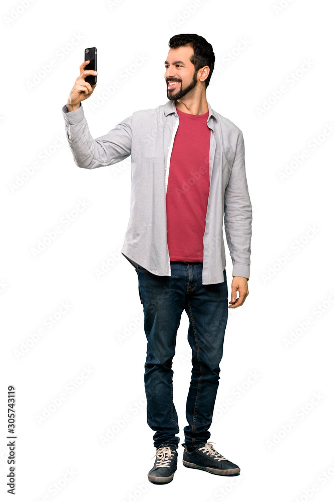 Full-length shot of Handsome man with beard making a selfie over isolated white background Full-length shot of Handsome man with beard making a selfie over isolated white background