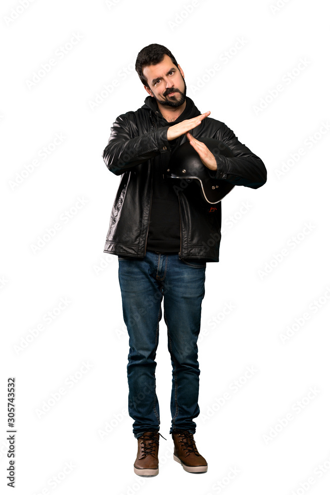 Full-length shot of Biker man making time out gesture over isolated white background Full-length shot of Biker man making time out gesture over isolated white background