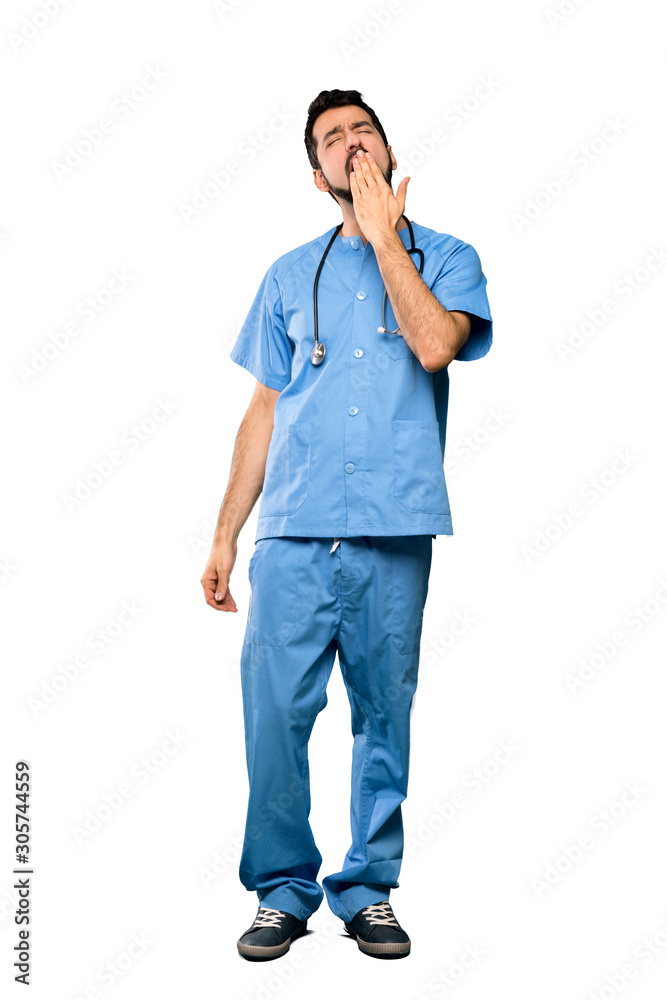 Full-length shot of Surgeon doctor man yawning and covering wide open mouth with hand over isolated white background
