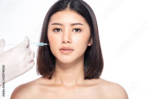 Asain young woman gets injection of botox in her lips. Woman in beauty salon. plastic surgery clinic.Beautiful woman gets botox injection in her face.